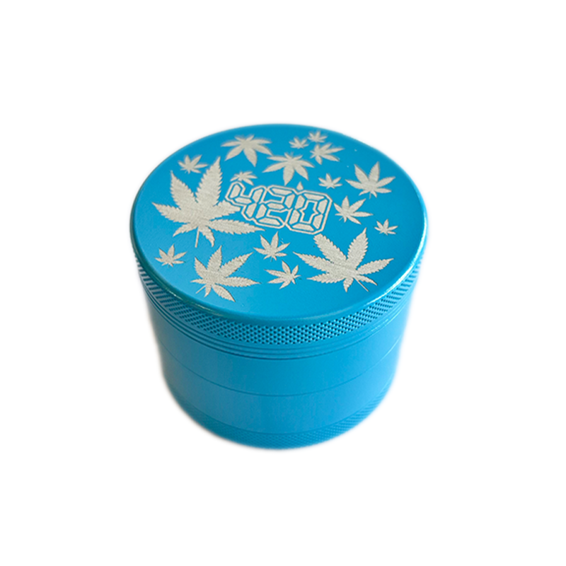 Keramik Grinder mit einem 63 Millimeter Durchmesser von der Marke NV. Die Farbe ist blau, mit einem silbernen Aufschrift und Hanfblättern.